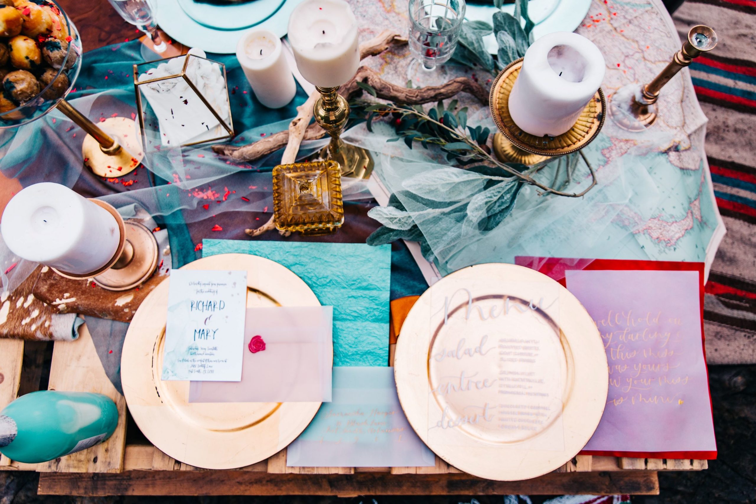 Colorful table setting with gold plates and candles for DIY weddings.