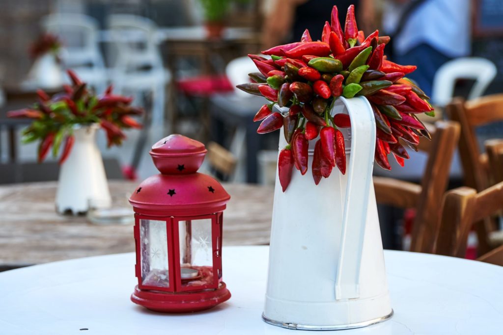 Table centerpiece with a white pitcher and red peppers for Denver weddings.