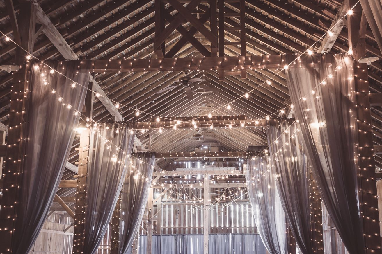 Fairy lights string lights wrapped around wooden beams DIY wedding