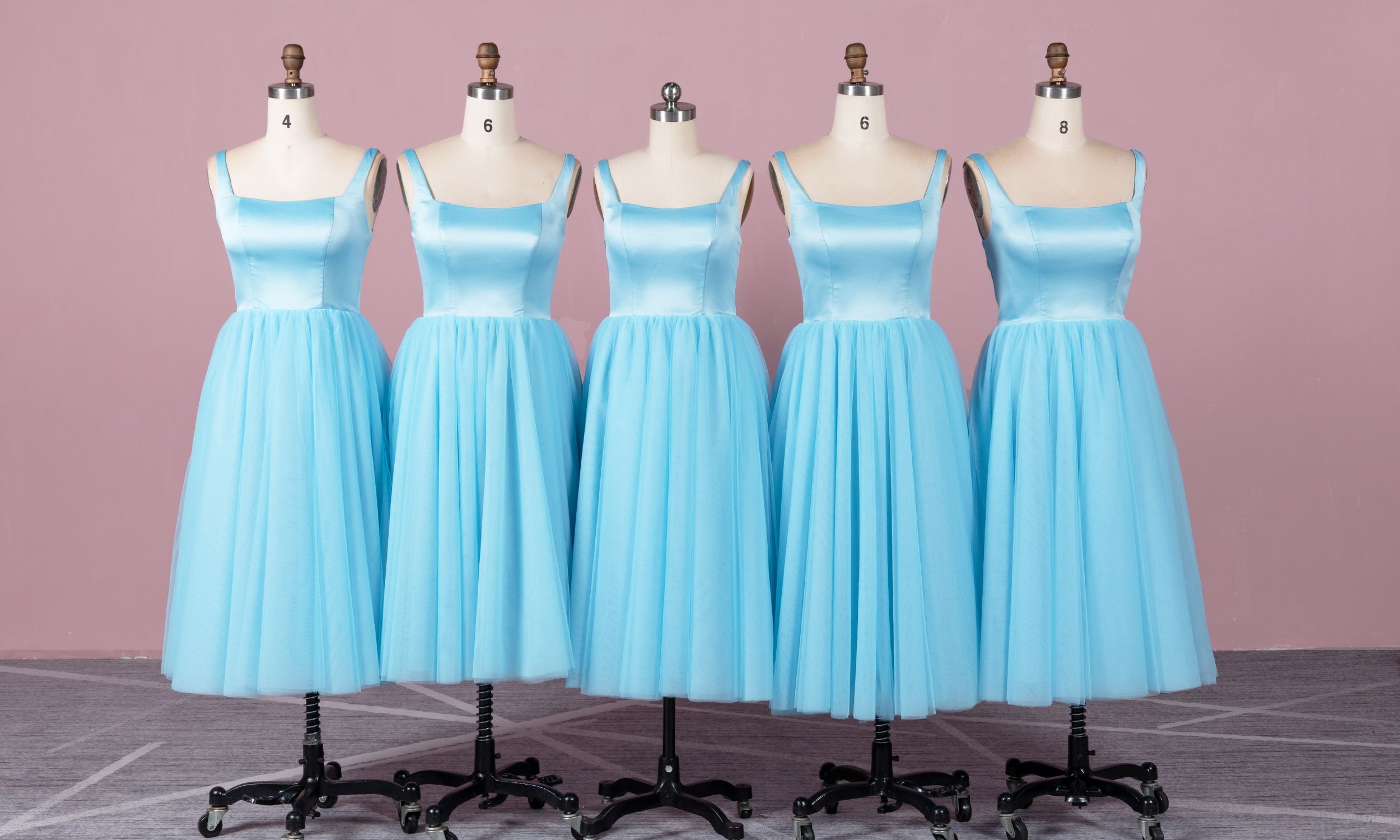 Five blue dresses on dress forms, bridesmaid dresses.