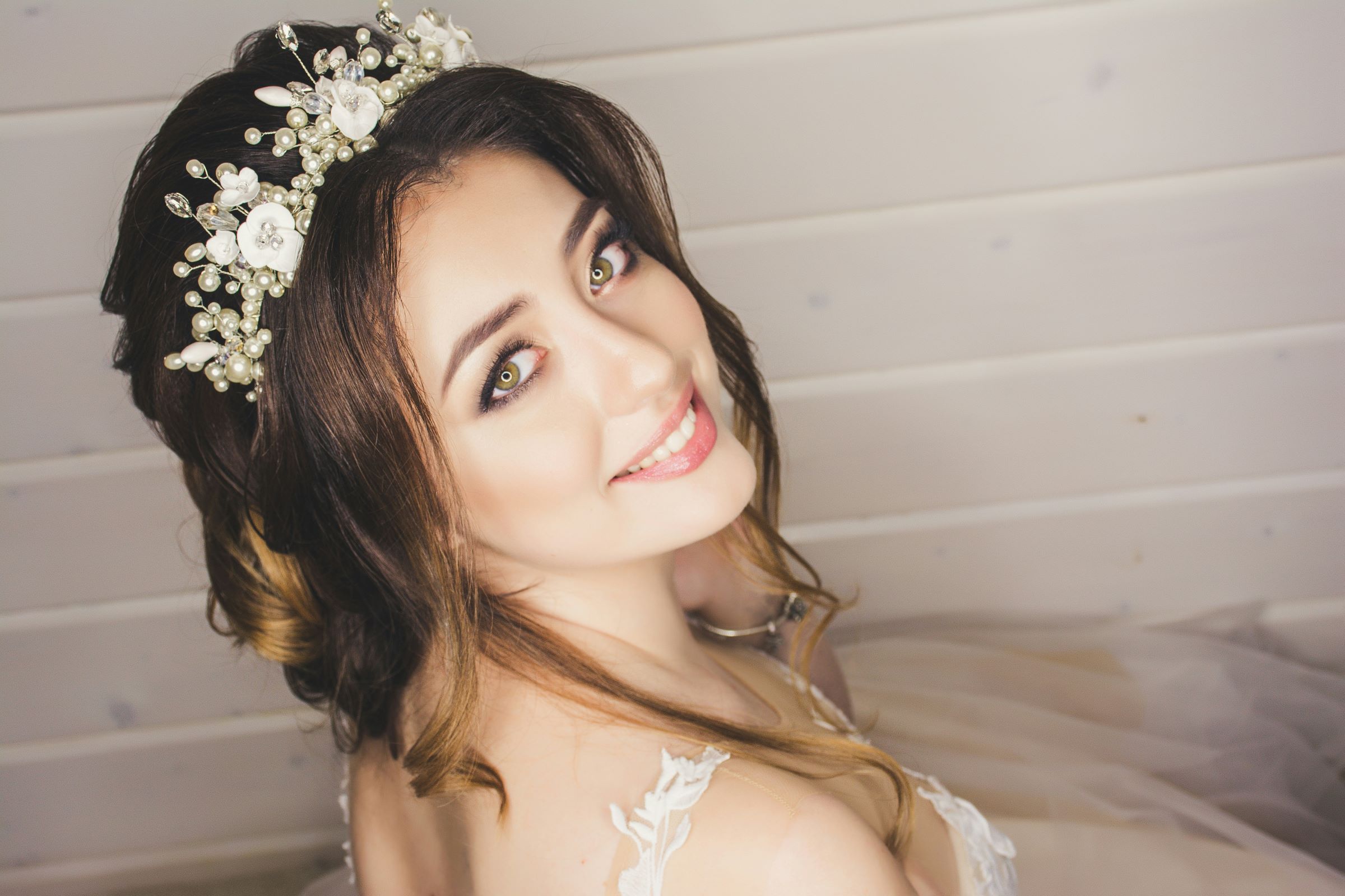 A bride looking up at the camera with a pearl headband